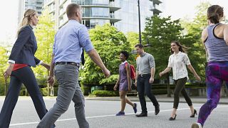 People cross a busy street