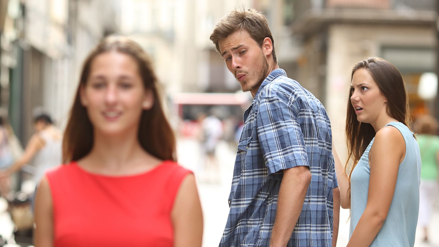 Disloyal man with his girlfriend looking at another girl
