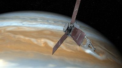 Artist\'s rendering showing NASA\'s Juno spacecraft making one of its close passes over Jupiter.