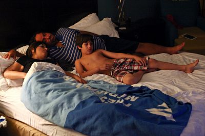Puerto Rican Waleska Rivera (L), 42, her husband Hector Oyola, 43, and their son Ethan Alejandro Oyola, 9, lie on a bed as Waleska undergoes her dialysis treatment in a hotel room, where she lives with her family, in Orlando, Florida on Dec. 7, 2017.