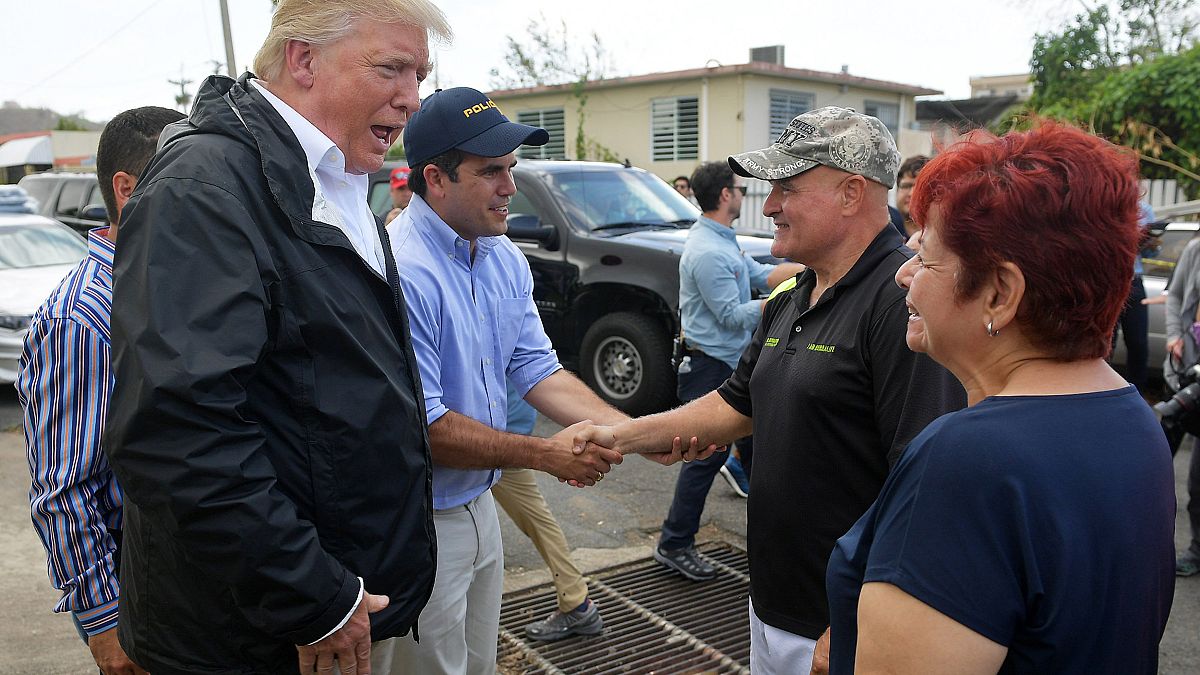 Image: U.S. President Donald Trump chats with residents in a storm damaged 