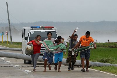 A father carries his sick child as its being transferred to another car as their ambulance is stucked on a highway by toppled electric posts caused by strong winds after Typhoon Mangkhut hit Baggao town in Cagayan province, north of Manila on Sept. 15, 2018.