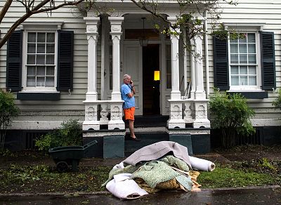 A man speaks on the phone as he cleans his home out from furniture damaged by floodwater from Hurricane Florence in New Bern, North Carolina on Sept. 15, 2018.