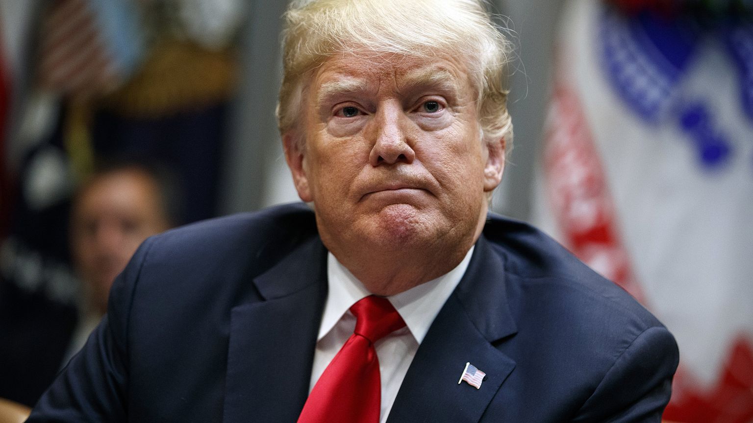 Image: Donald Trump listens to a question from a reporter during a meeting 