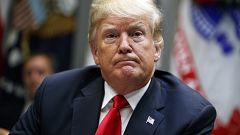 Image: Donald Trump listens to a question from a reporter during a meeting 