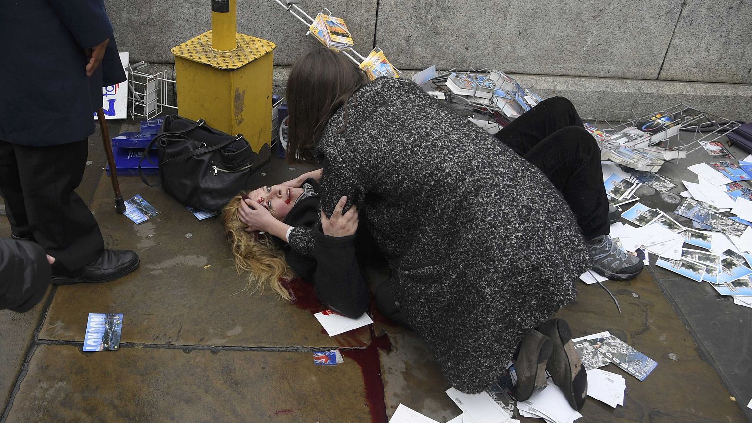 Image: A woman lies injured after a shotting incident on Westminster Bridge