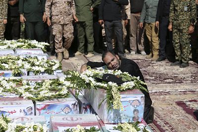 The father of Mohammad Taha Eghadami, a 4-year-old boy who was killed in Saturday\'s attack, mourns atop his coffin Monday.