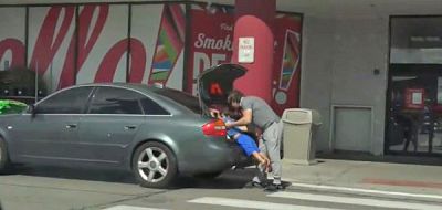 Boguslaw Matlak places his son in the trunk of his car during what he said was a hidden camera experiment.