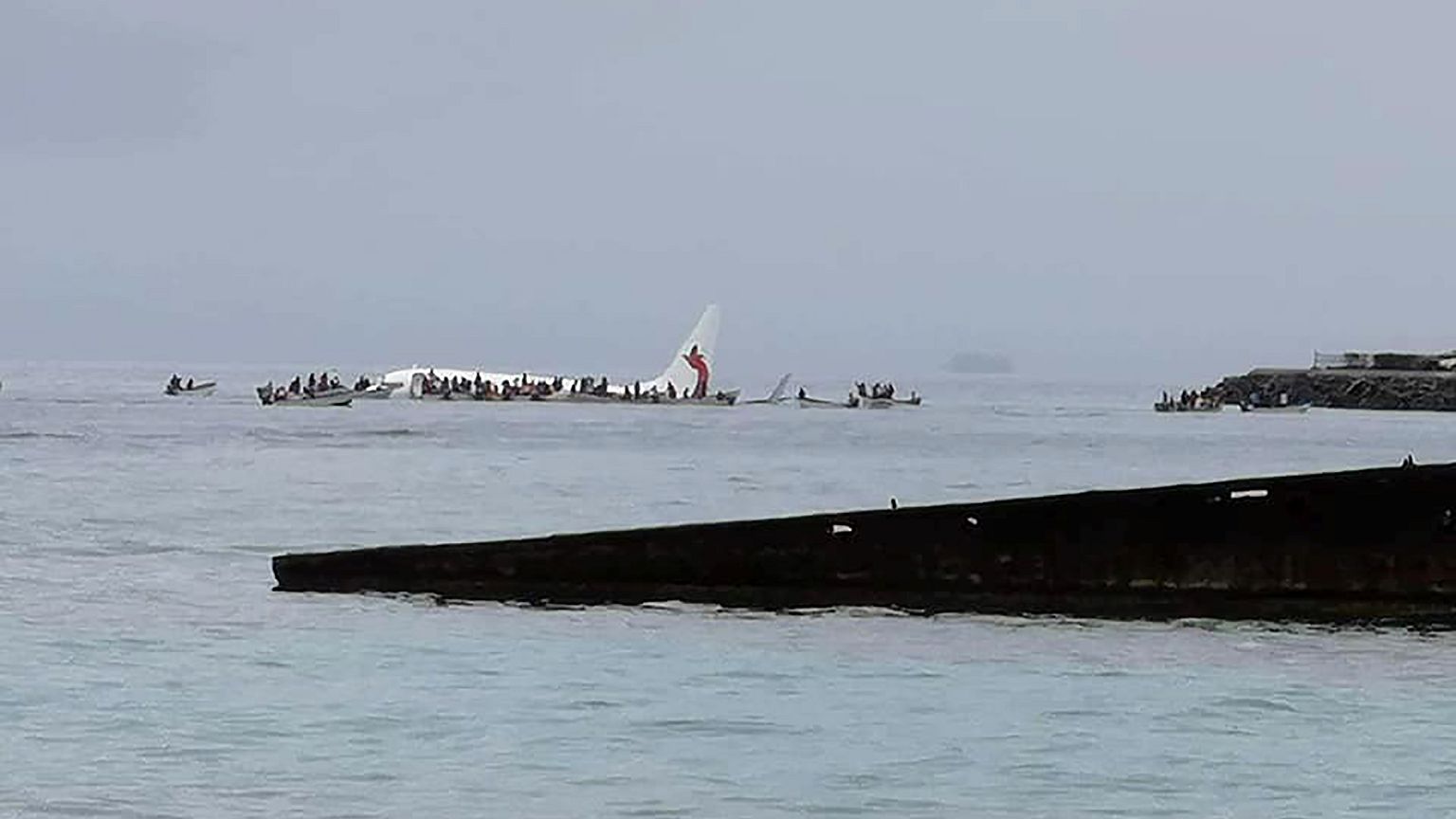 Image: People are evacuated from an Air Niugini plane which crashed in the 