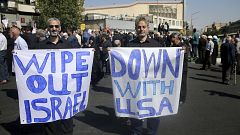 Image: Men hold up anti-American and anti-Israeli placards at a rally conde