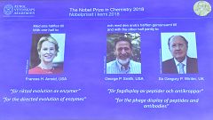 Image: The 2018 Nobel Prize laureates for Chemistry are shown on the screen