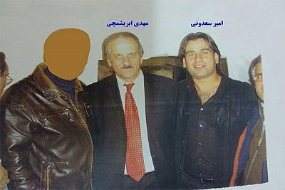 An undated photo distributed July 3, 2018 by the Iranian Foreign Ministry shows a man the Ministry says is Amir Soudani, right, next to a man it says is Mehdi Abrishamchi, center, a top MEK official in Europe. The face of the person on the left has been blotted out by the Ministry for what it says are security reasons.