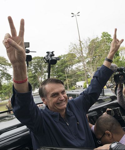 Brazilian presidential candidate Jair Bolsonaro, of the far-right Social Liberal Party, flashes victory hand signs to supporters after voting in Rio de Janeiro on Sunday.