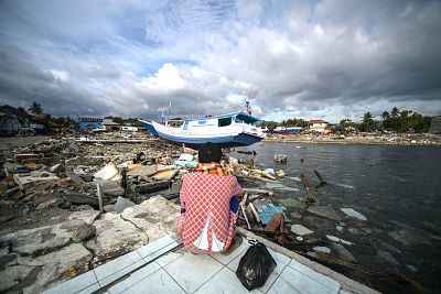 A resident looks at a boat washed ashore in Wani, on the island of Sulawesi, on Oct. 7, following the Sept. 28 earthquake and tsunami.
