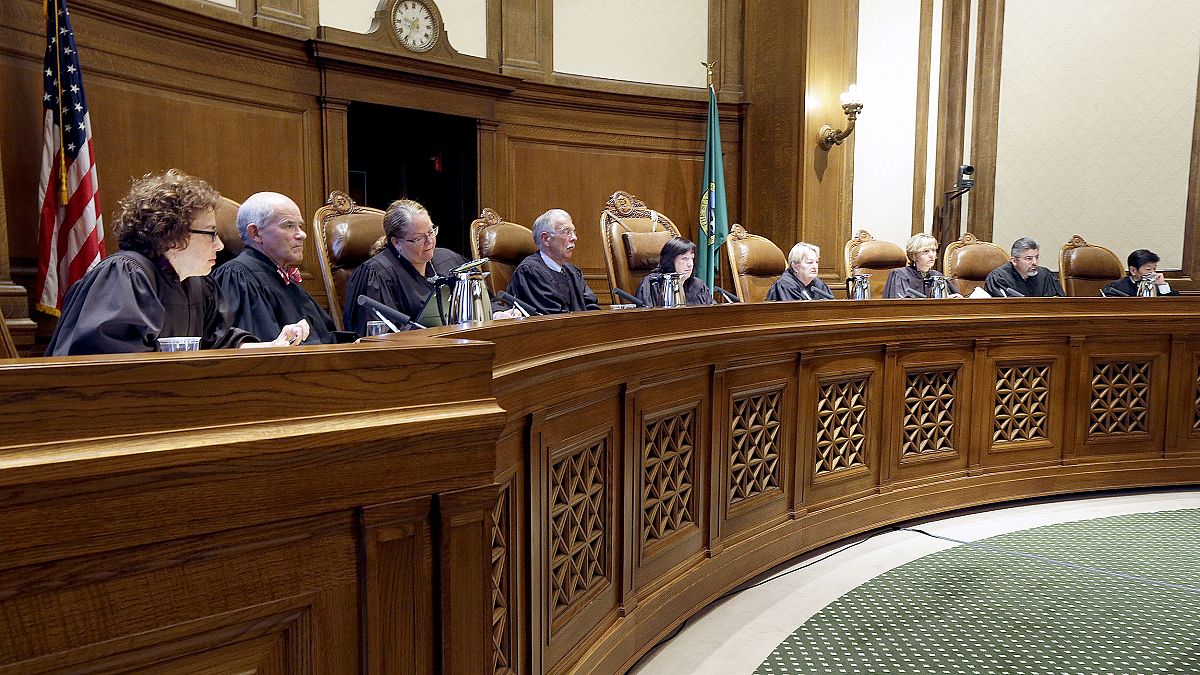 Justices on the Washington state Supreme Court listen during a hearing in O