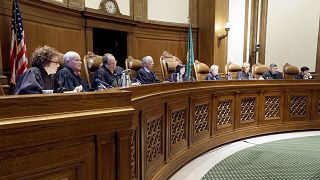 Justices on the Washington state Supreme Court listen during a hearing in O