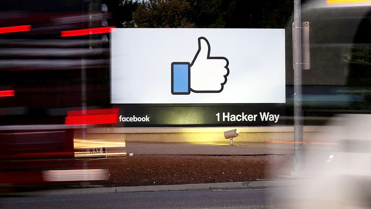 Image: The entrance sign to Facebook headquarters is seen through two movin