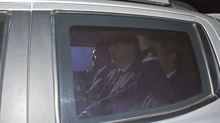 Image: Andrew Brunson, center, sits inside a car as he arrives for his tria