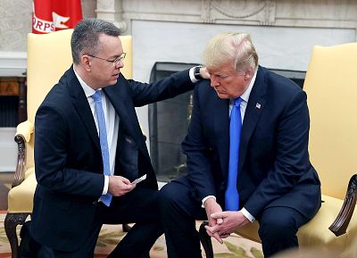 U.S. President Donald Trump and American evangelical Christian preacher Andrew Brunson participate in a prayer a day after he was released from a Turkish jail, in the Oval Office, on October 13, 2018, in Washington.