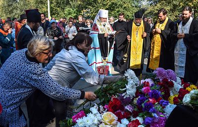People lay flowers for the victims during a church service in Kerch, Crimea, on Oct. 18, 2018, after a student opened fire at a technical college in the Russian-annexed Crimea city of Kerch.