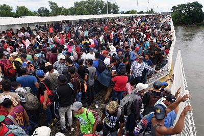 Honduran migrants taking part in a caravan to the United States wait to cross to Mexico in Ciudad Tecun Uman, Guatemala, on Saturday.