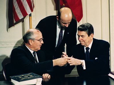 President Ronald Reagan, right, and Soviet leader Mikhail Gorbachev exchange pens during the Intermediate Range Nuclear Forces Treaty signing ceremony on Dec. 8, 1987. Gorbachev\'s translator Pavel Palazhchenko stands in between the men.