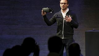 Oculus CEO Brendan Iribe displays a virtual reality headset during an event