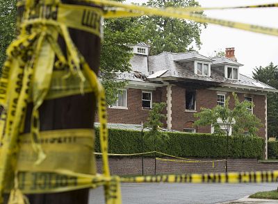 Police vehicles are seen outside a fire-damaged home where four people were killed last week in Washington, D.C., on May 21, 2015.