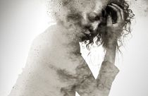 Unhappy woman's form double exposed with paint splatter effect