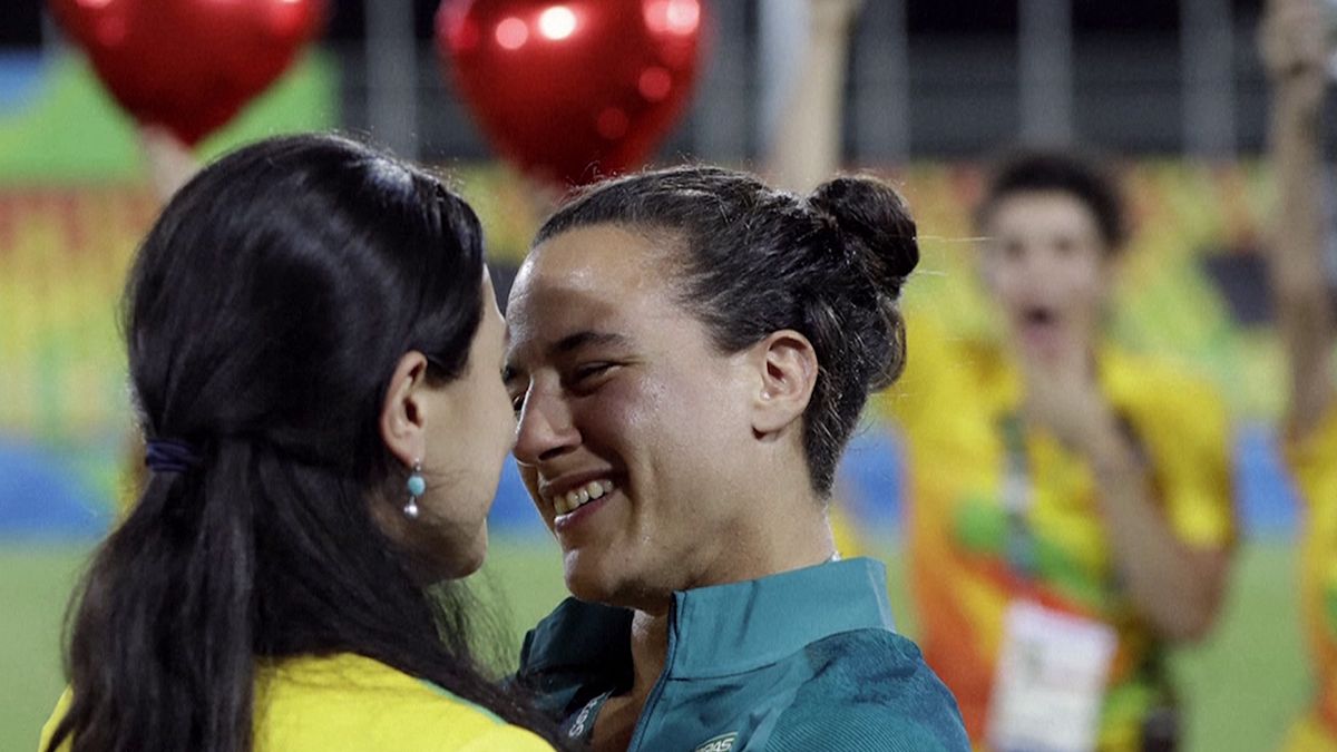 Una jugadora de rugby da el "sí quiero" a una voluntaria en la ceremonia de entrega de medallas