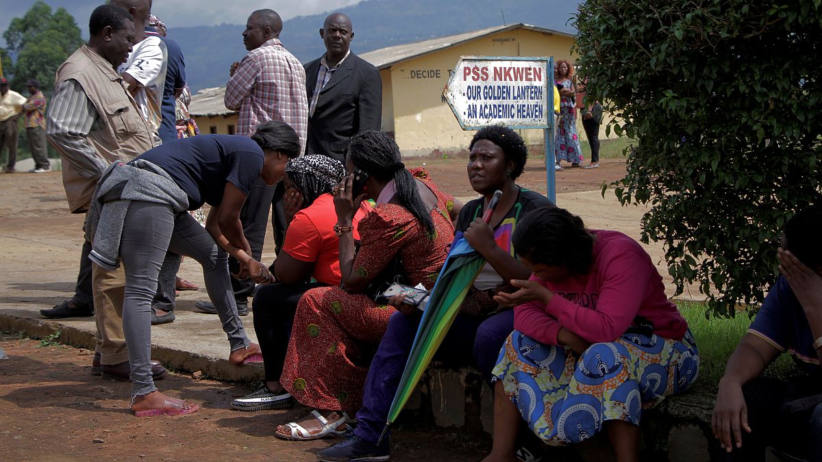 Image: Parents await for news of their children at a school where 79 pupils