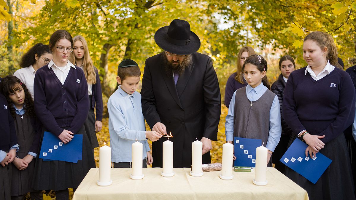 Rabbi Yehuda Teichtal lights candles with students during an event to mark 