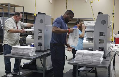 Election workers place ballots into electronic counting machines, on Nov. 11, 2018, at the Broward Supervisor of Elections office in Lauderhill, Florida. The Florida recount began Sunday morning in Broward County.