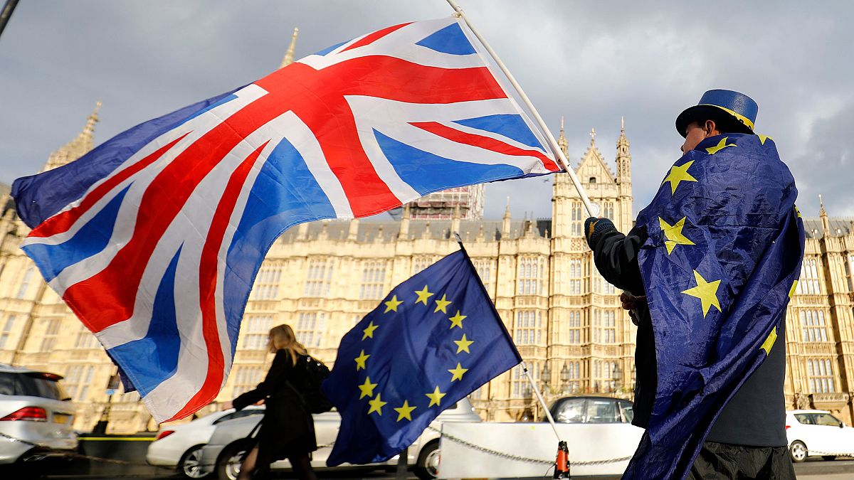 Image: An anti-Brexit demonstrator waves a Union flag alongside a European 