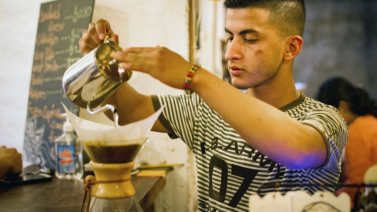Jorge Suarez, making a coffee at his small business, the Ik-ro Cafe Bar in 