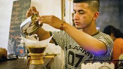 Jorge Suarez, making a coffee at his small business, the Ik-ro Cafe Bar in 