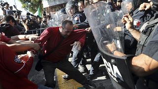 Demonstrators clash with police outside a migrant shelter as they protest t