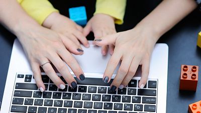 Mother working oh laptop with her toddler child Mother working oh laptop with her toddler child