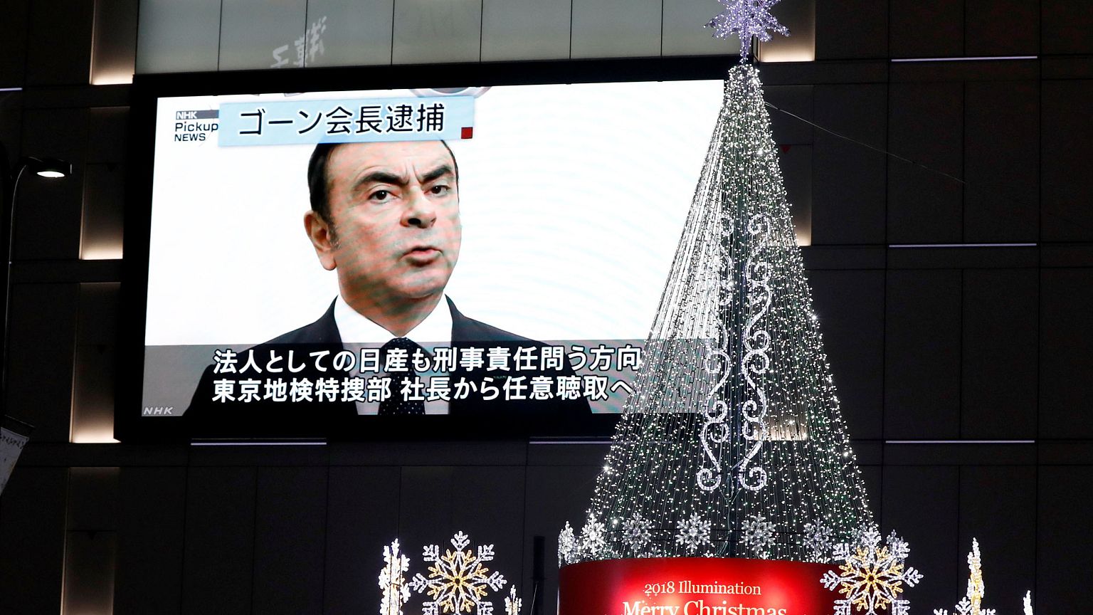 Image: A street monitor showing a news report about arrest of Nissan Chairm