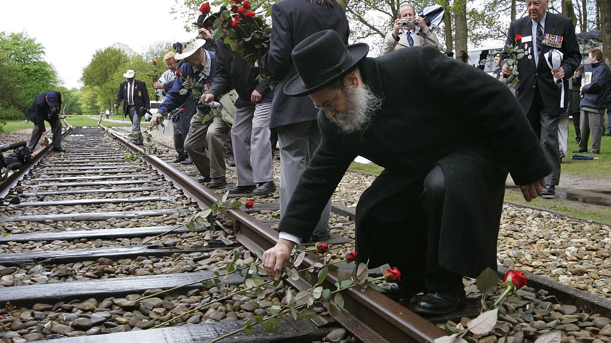A rabbi places a rose on rail tracks near Westerbork, a former transit camp