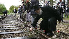 A rabbi places a rose on rail tracks near Westerbork, a former transit camp