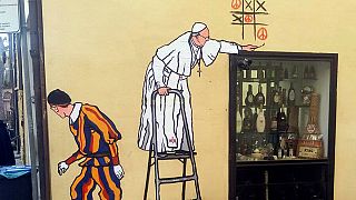 La "Policía del decoro" borra un grafiti del papa jugando al tres en raya de la paz