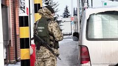Image: An armed officer of Ukraine's State Border Guard Service addresses a