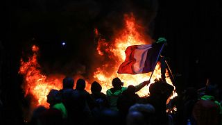 Image: Protestors fly a French flag during a protest of Yellow vests (Gilet