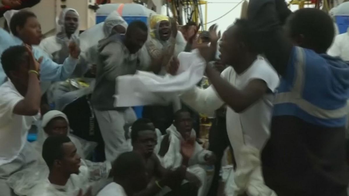 Migranten singen und tanzen auf der Reise nach Italien