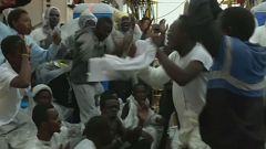 Migranten singen und tanzen auf der Reise nach Italien