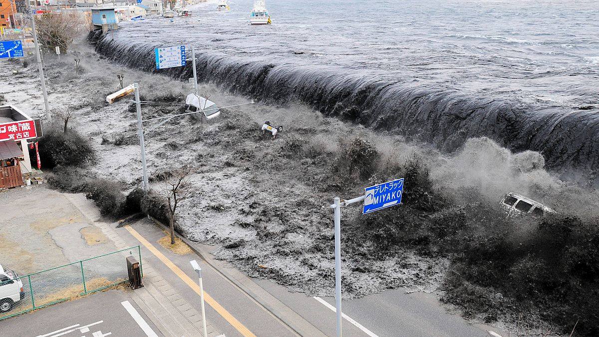 Waves approach Miyako City after a 9.0 magnitude earthquake hit Japan and t
