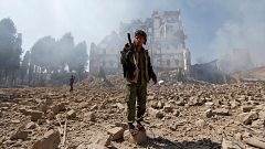Image: Huthi rebel fighters inspect the damage after a reported air strike 