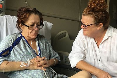 Michele De Leeuw recovers in the hospital, with her friend by her side.