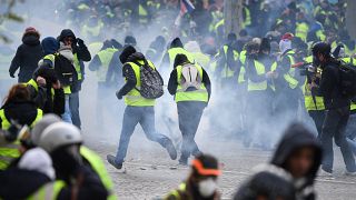 Image: Protesters run through tear gas in Paris on Saturday